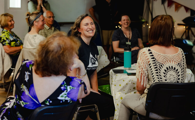 Lady smiles seated at a table during an event